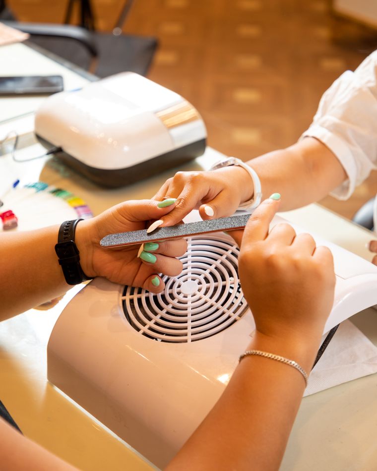 Manicurista atendiendo a una clienta en un salón de uñas