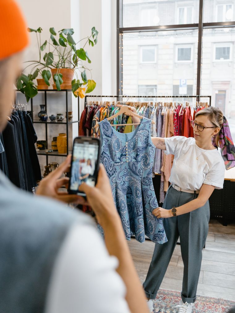 Dueña de una boutique mostrando un vestido